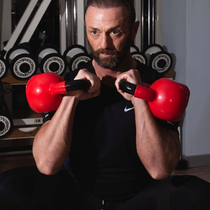 Angelo con due kettlebell rossi