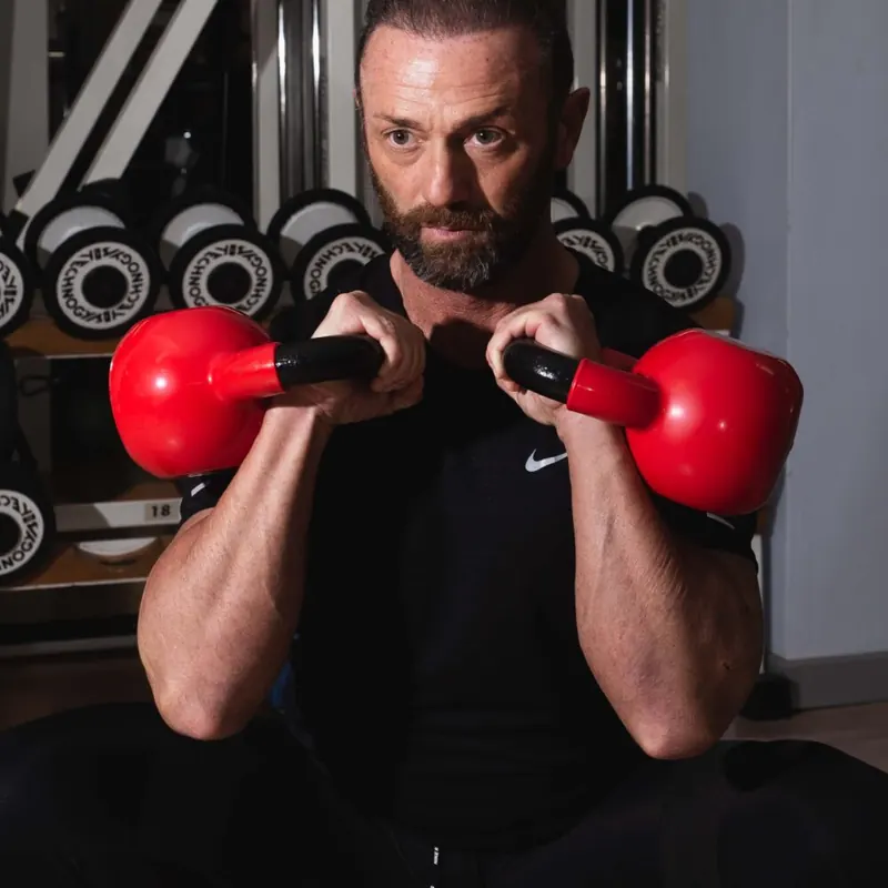 Angelo con due kettlebell rossi